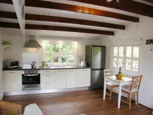 een keuken met witte kasten en een tafel met stoelen bij Cottage Bougainville in La Orotava