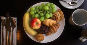 a white plate of food with grapes and other foods at Holiday Inn York by IHG in York