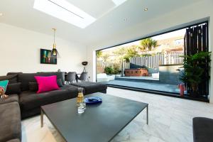 a living room with a couch and a table at Villa Neptune at Rounton Villa by Maison Parfaite - Hot Tub - Parking - Robin Hoods Bay in Robin Hood's Bay