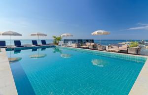 a large swimming pool with chairs and umbrellas at H10 Imperial Tarraco 4 Sup in Tarragona