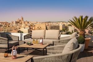 a rooftop patio with furniture and a view of the city at H10 Imperial Tarraco 4 Sup in Tarragona