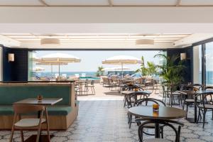 a restaurant with tables and chairs and a view of the ocean at H10 Imperial Tarraco 4 Sup in Tarragona