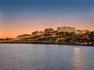 a view of a city from the water at sunset at H10 Imperial Tarraco 4 Sup in Tarragona