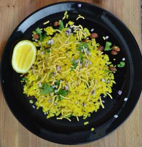 un plato negro de comida con arroz y limón en Narain's Homestay, en Kāshīpur