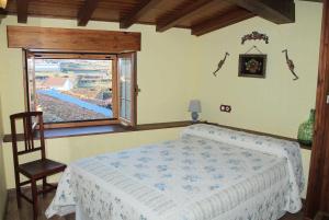 a bedroom with a large bed and a window at Casa Rural con encanto en Las Arribes Abuelo Román in Masueco