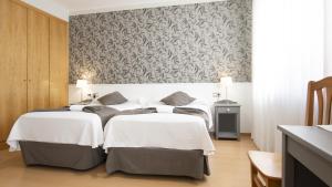 a bedroom with two beds and a patterned wall at Hotel Isabel de Segura in Teruel +37 photos