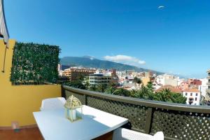 a balcony with a table and chairs and a city at Atico junto al mar in Puerto de la Cruz