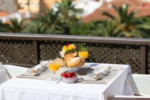 a table with a plate of food and glasses of orange juice at Atico junto al mar in Puerto de la Cruz