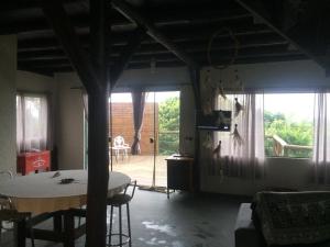 una sala de estar con mesa y una habitación con patio en Linda casa na Gamboa Garopaba, en Garopaba