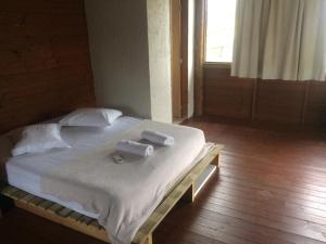 a bedroom with a bed with two towels on it at Linda casa na Gamboa Garopaba in Garopaba