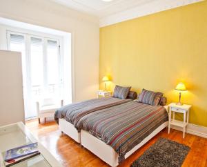 ein Schlafzimmer mit einem Bett mit zwei Tischen und zwei Lampen in der Unterkunft Gulbenkian in Lissabon