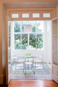 ein Esszimmer mit einem Tisch, Stühlen und einem Fenster in der Unterkunft Gulbenkian in Lissabon