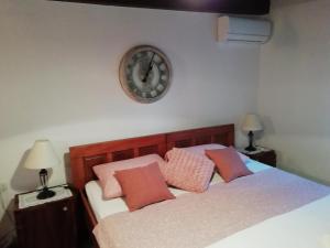 ein Schlafzimmer mit 2 Betten und einer Uhr an der Wand in der Unterkunft Near beach - Apartment Butiga in Rovinj