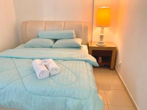 een slaapkamer met een bed met twee handdoeken erop bij SEA LA VIE @ LAGUNA CONDO RESORT in Port Dickson