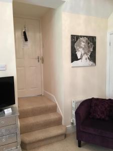 a living room with stairs and a tv and a door at Fring House Bed and Breakfast in Seaton