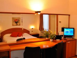 sypialnia z łóżkiem i biurkiem z komputerem w obiekcie Golf Hotel w mieście Lainate