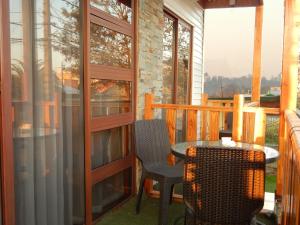 a porch with a table and chairs on a balcony at Hostal Plaza Maule in Talca