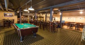 a pool table in a room with tables and chairs at The Bethel Resort & Suites in Bethel