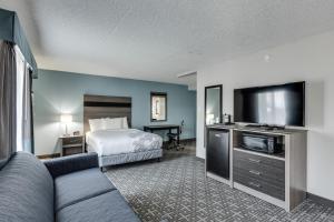 a hotel room with a bed and a flat screen tv at Days Inn & Suites by Wyndham Spokane in Spokane
