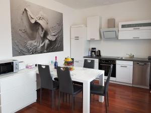 a kitchen with a white table and chairs in it at Ferienwohnung "Im Türmchen" inklusive WLAN, Parkplatz und Netflix in Schleiden