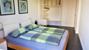 um quarto com uma cama azul e 2 almofadas em Ferienwohnungen Hankenstraße em Bremen