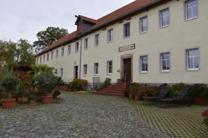 ein großes weißes Gebäude mit einem Innenhof mit Topfpflanzen in der Unterkunft Ferienwohnung Kleinmockritz in Döbeln