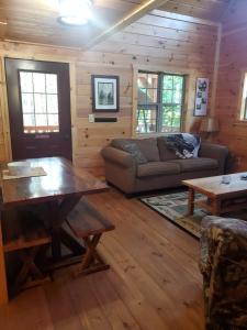 a living room with a couch and a table at The Frontier - An Amish Built Deluxe Cabin in Genoa