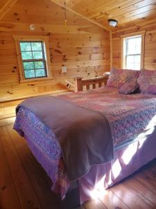 a bedroom with a bed in a wooden cabin at The Frontier - An Amish Built Deluxe Cabin in Genoa
