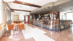 un bar en un restaurante con mesas y sillas en Hotel Isabel de Segura, en Teruel