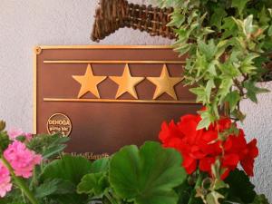 a sign with four stars on it next to flowers at Hotel Daimerwirt in Moosinning
