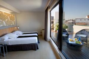 a hotel room with a bed and a large window at Hotel Opera in Madrid