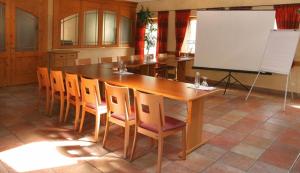 eine Küche mit einem großen Holztisch und Stühlen in der Unterkunft Hotel Daimerwirt in Moosinning