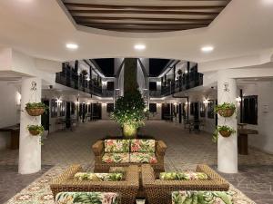 a lobby with couches and tables in a building at Casa Hotel Las Orquideas in Circasia