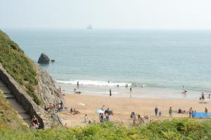 a group of people on a beach near the ocean at East Trewent Farm in Pembroke