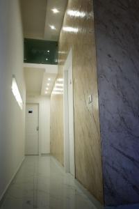 um corredor de um edifício de escritórios com uma parede branca e roxa em Elegance B&B em Nápoles