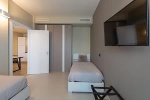um quarto com uma cama e uma televisão de ecrã plano em ATMOSFERA APARTMENTS & SUITES em Borgaro Torinese