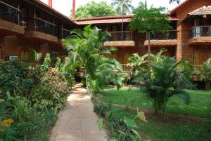 a walkway in front of a building with palm trees at Sea Breeze Beach, Calangute, Goa in Calangute