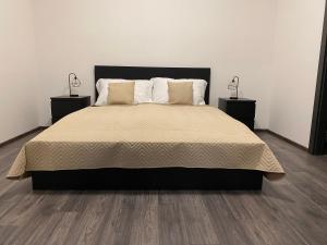 1 dormitorio con 1 cama grande y 2 mesitas de noche en Boutique Apartments Liberec, en Liberec
