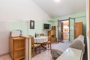 ein Wohnzimmer mit einem Tisch und einer Küche in der Unterkunft Apartment Buic in Pula