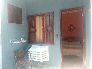 ein blaues Zimmer mit einem Tisch, einem Stuhl und einem Fenster in der Unterkunft Pousada Telhado Azul in Abraão