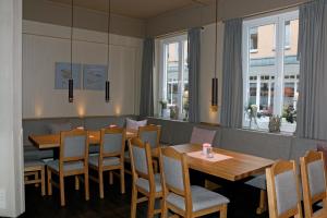 un ristorante con tavoli e sedie in legno e finestre di Hotel Restaurant Vogt a Rietberg