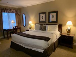 a bedroom with a large bed with two lamps and a desk at The Bethel Inn Resort in Bethel