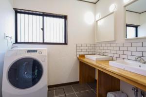 W łazience znajduje się pralka i umywalka. w obiekcie Sky House Fujikawaguchiko - Vacation STAY 98122 w mieście Azagawa