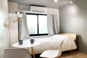 東京にあるEbisu Ebisu - Vacation STAY 98240の小さなベッドルーム(ベッド1台、テーブル、窓付)