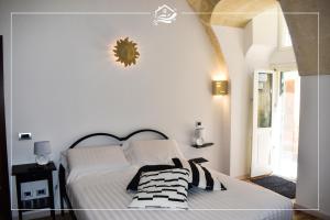 a bedroom with a white bed with black and white pillows at Acqua Dolce in Matera