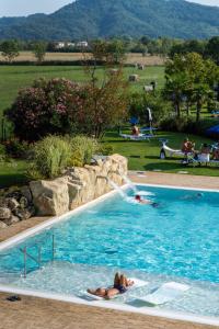 una persona nadando en una piscina con una fuente de agua en Hotel Terme Leonardo en Abano Terme