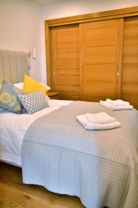 1 dormitorio con 1 cama con 2 toallas en Red Watch Apartment, en Oban