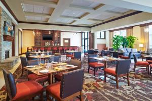ein Restaurant mit Tischen und Stühlen und einem Kamin in der Unterkunft Sheraton Augusta Hotel in Augusta
