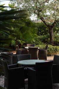 een tafel en stoelen op een patio met een boom bij Hotel Terme Leonardo in Abano Terme