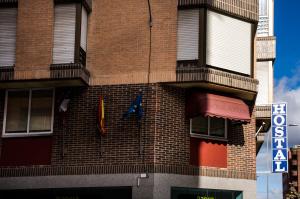 a brick building with a flag on the side of it at Hostal Algodon in Palencia
